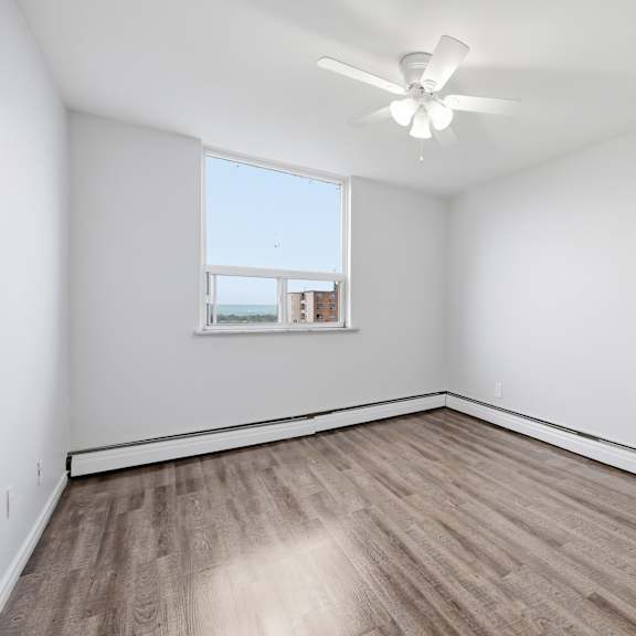empty room with a ceiling fan and a window.