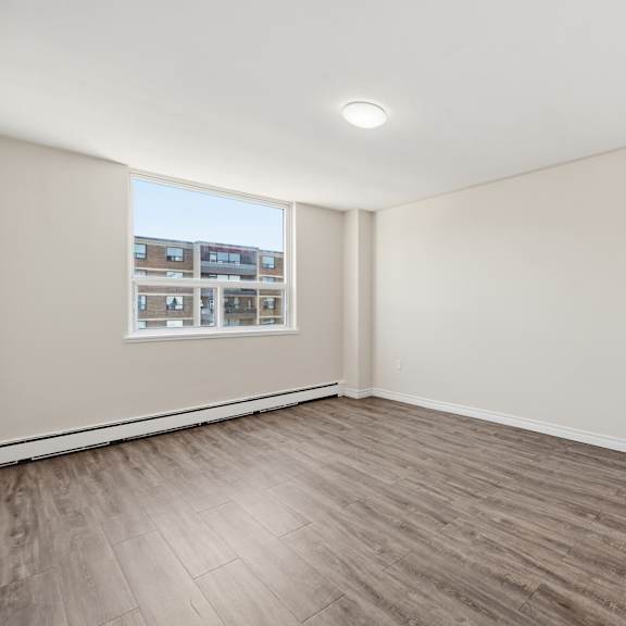 a room with a window and a wooden floor.
