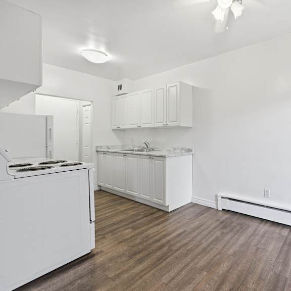 a kitchen with white cabinets and a white stove top oven.