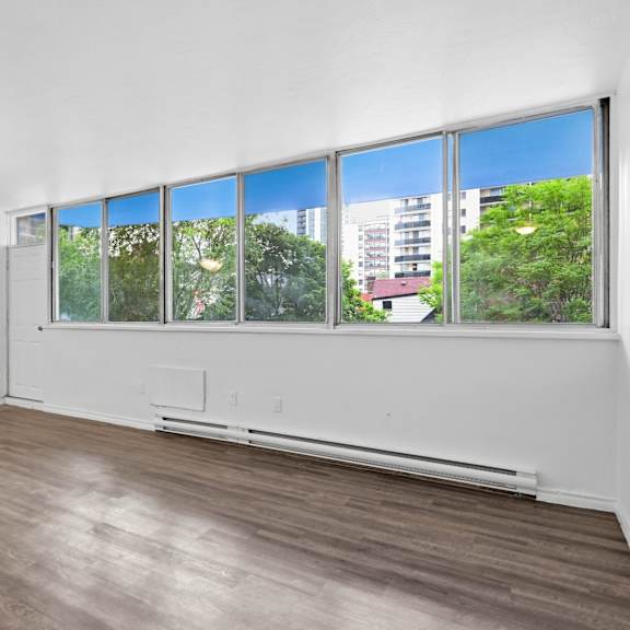 a room with a large window and a wooden floor.