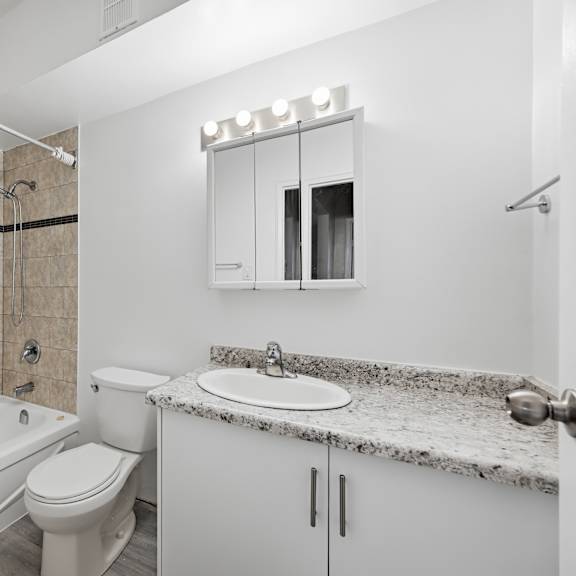 a white bathroom with a tub, toilet, and sink.
