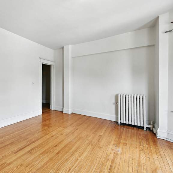 a room with wooden floors and white walls.