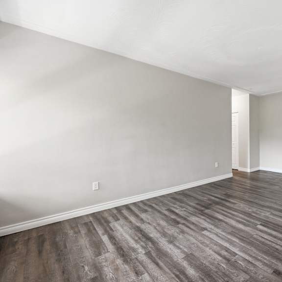 a room with wooden flooring and white walls.