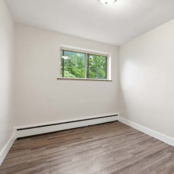 a room with a window and wooden flooring.