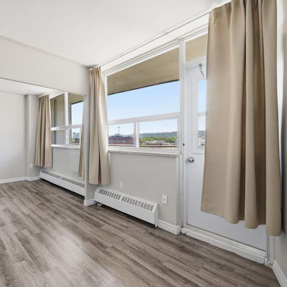 a room with a sliding glass door and a window with curtains.