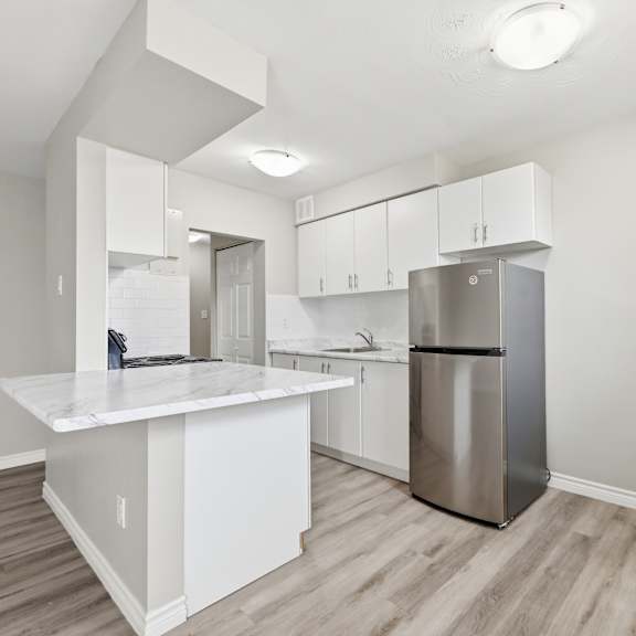 a kitchen with a white island and stainless steel appliances.