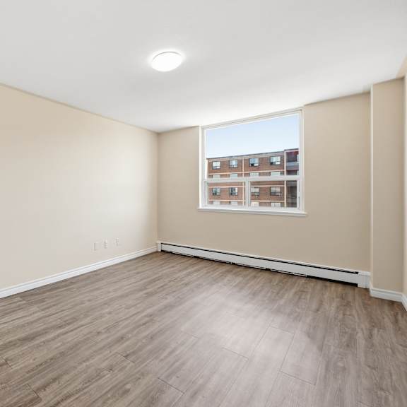empty room with wooden flooring and a window.