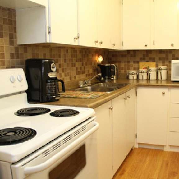 a kitchen with a white stove and white cabinets.