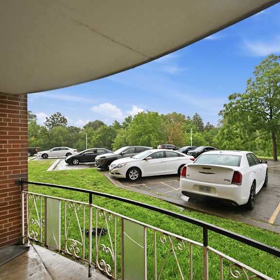 a parking lot with cars and trees in the background.