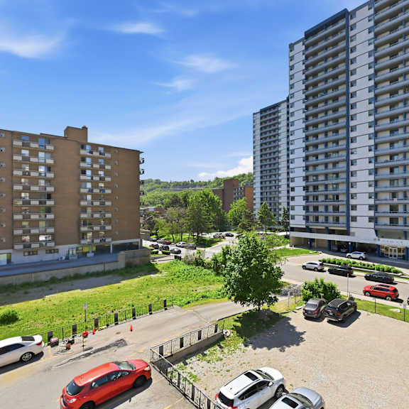 a parking lot with cars and apartment buildings in the background.
