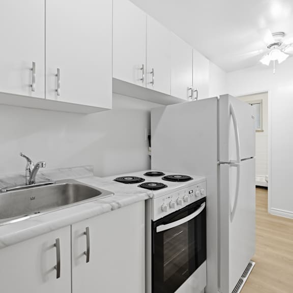 a kitchen with white cabinets and appliances.