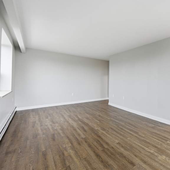 empty room with wooden flooring and white walls.