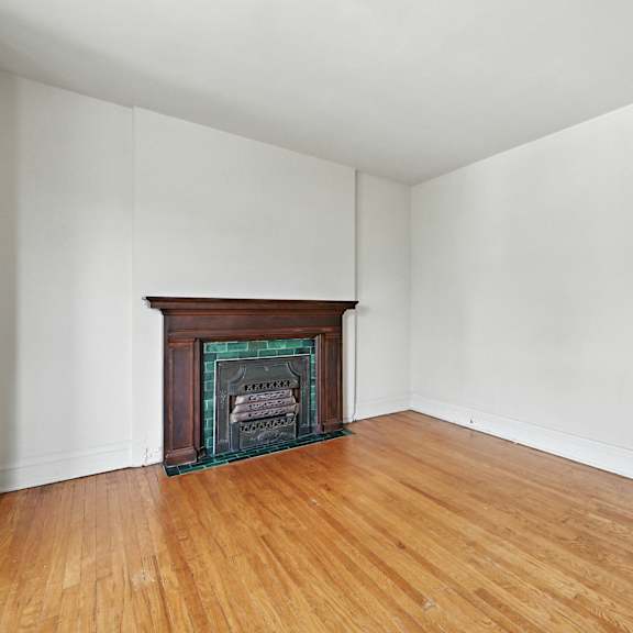 a room with a fireplace and wooden floors.