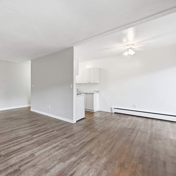 a room with wooden flooring and white walls.