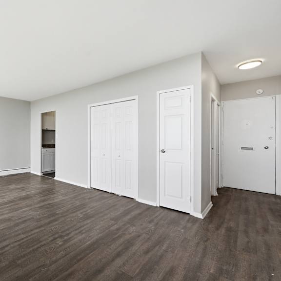 a room with white walls and wooden flooring.