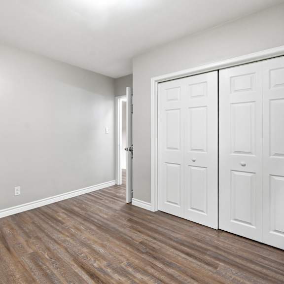 a room with a white door and wooden flooring.