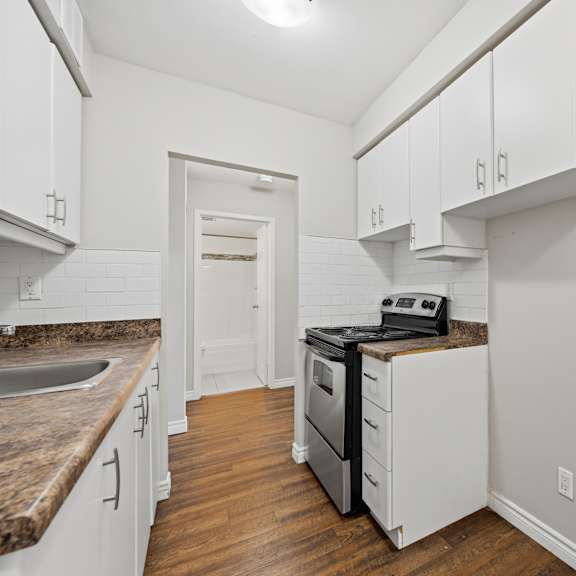a kitchen with white cabinets and a black stove top oven.