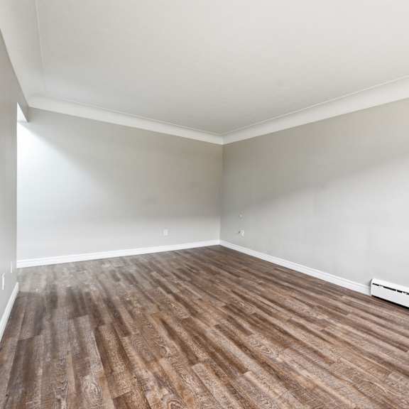 a room with wooden flooring and white walls.