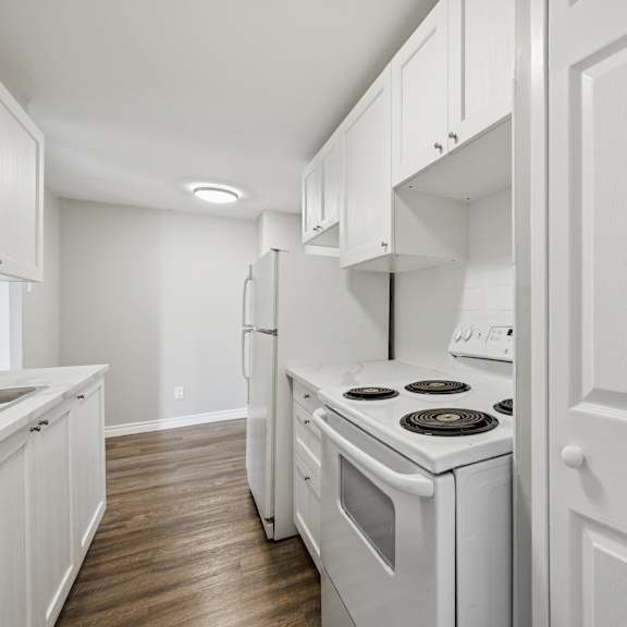 a white kitchen with a stove and oven.
