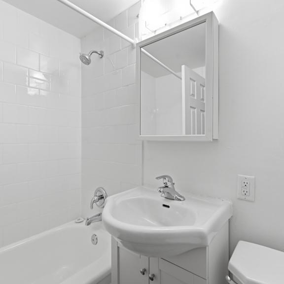 a white bathroom with a sink, toilet, and bathtub.