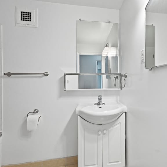 a white sink in a bathroom with a mirror above it.