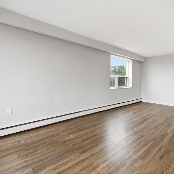 empty room with wooden flooring and a window.