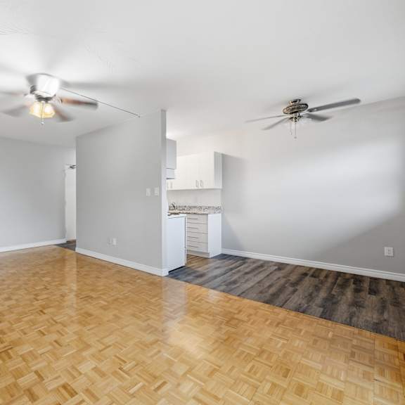 a room with a wooden floor and two ceiling fans.