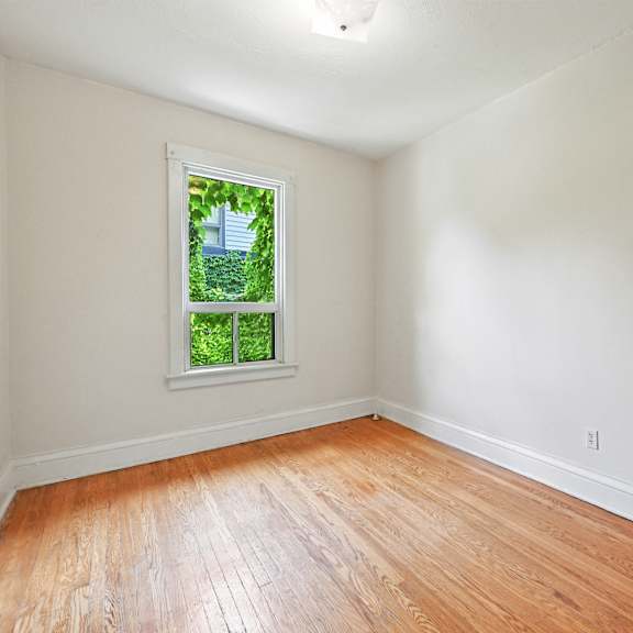 a room with a window and wooden flooring.