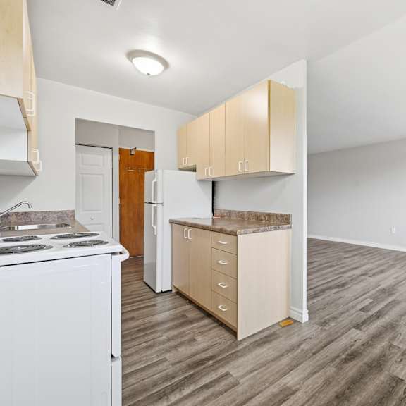 a kitchen with white appliances and wooden cabinets.