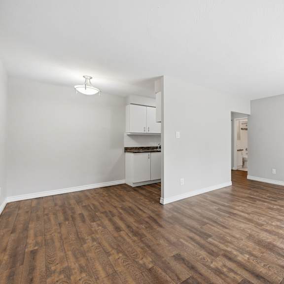 a room with wooden floors and white walls.