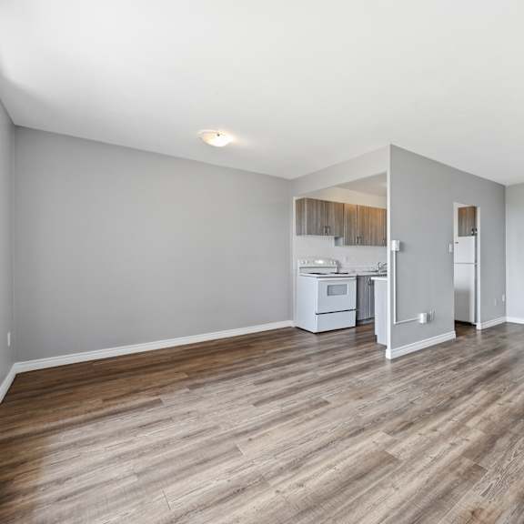 a kitchen with a refrigerator, microwave, and oven is visible through a doorway.