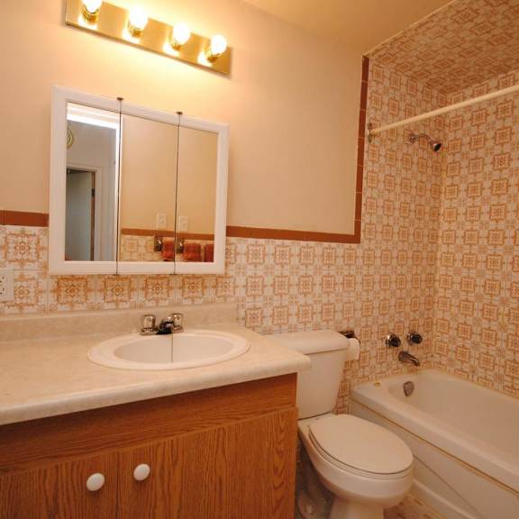a bathroom with a sink, toilet, and bathtub.