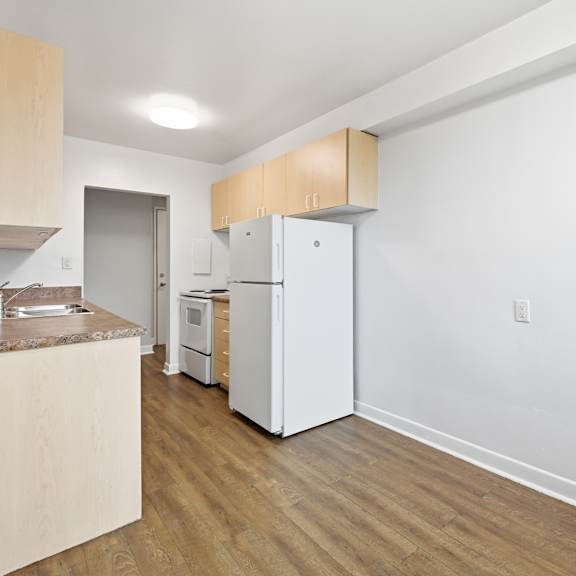 a kitchen with a white fridge and a white oven.