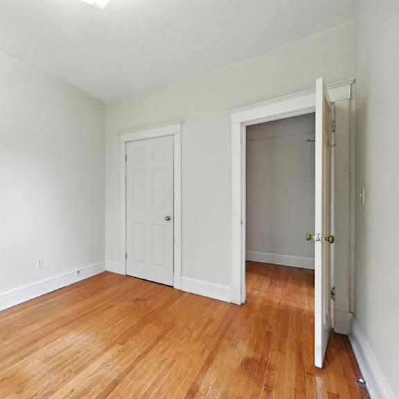 a room with a white door and a wooden floor.