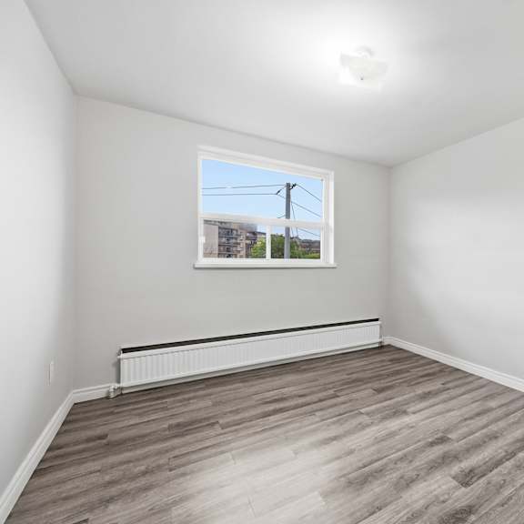 a room with a window and wooden flooring.