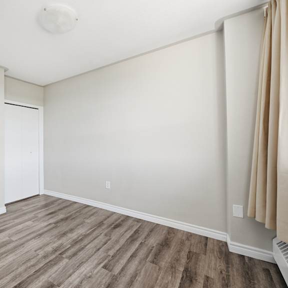 a room with a wooden floor and white walls.
