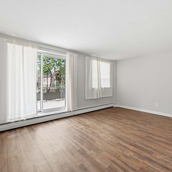 a room with a window and wooden flooring.