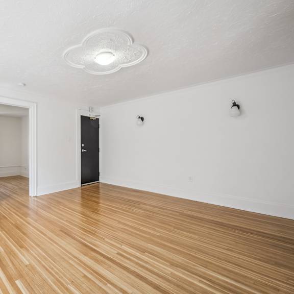 a room with wooden floors and a black door.