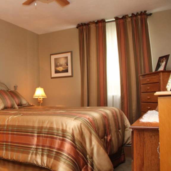 a bedroom with a bed, nightstand, and pictures on the wall.