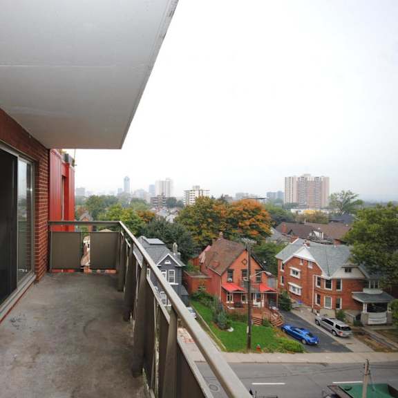a balcony with a brick wall and a view of a residential area.