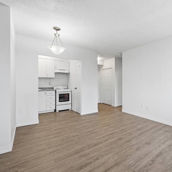 a kitchen with white cabinets and a wooden floor.