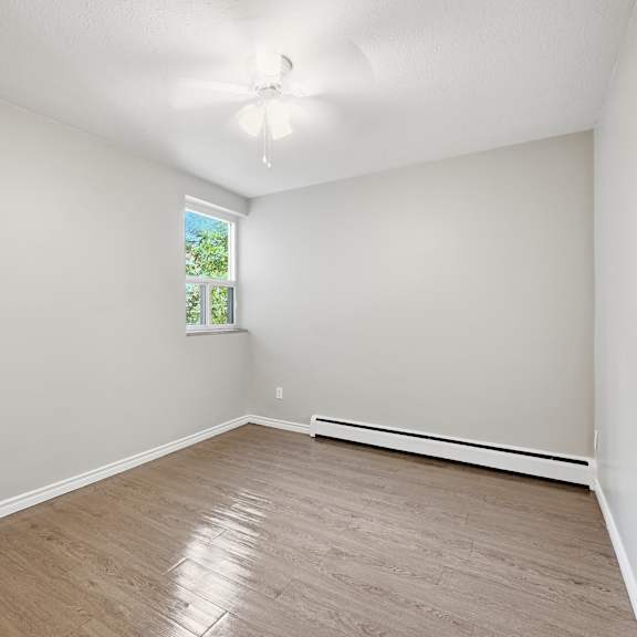 a room with a window and a ceiling fan.