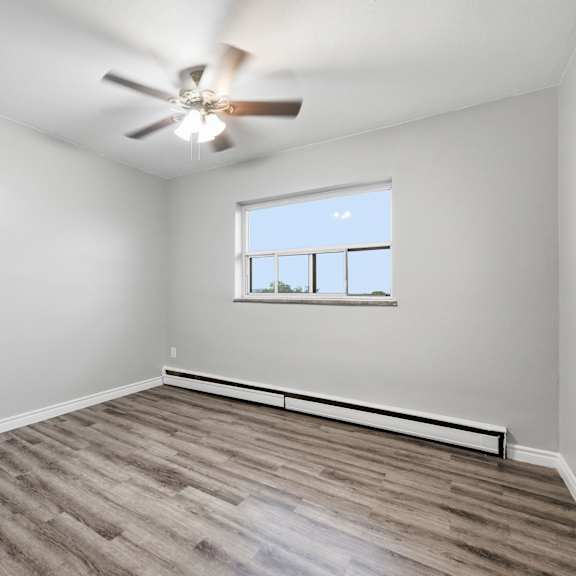 a room with a ceiling fan and a window.