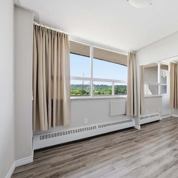 a room with a window and a wall-mounted heater.