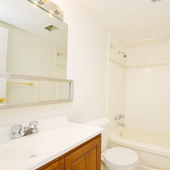 a white bathroom with a toilet, sink, and bathtub.