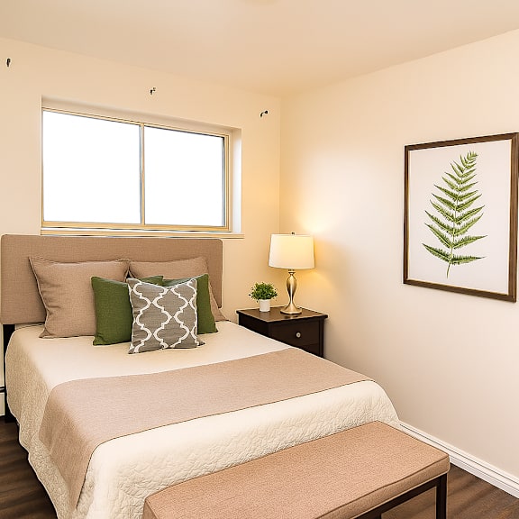 a bedroom with a bed, nightstand, and a framed leaf picture on the wall.