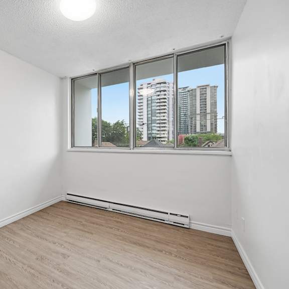 a room with a window showing a view of a cityscape.