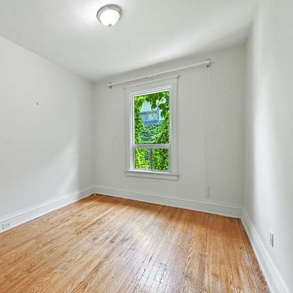 a room with a window showing a green landscape outside.