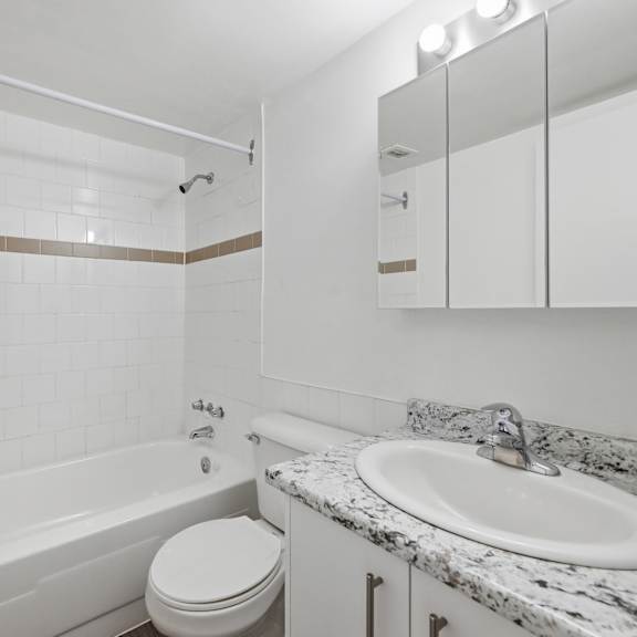 a white bathroom with a toilet, sink, and bathtub.