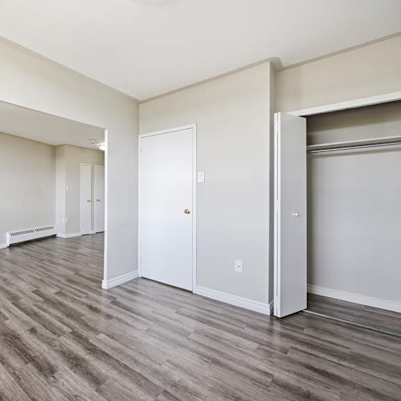 a room with wood flooring and white walls.